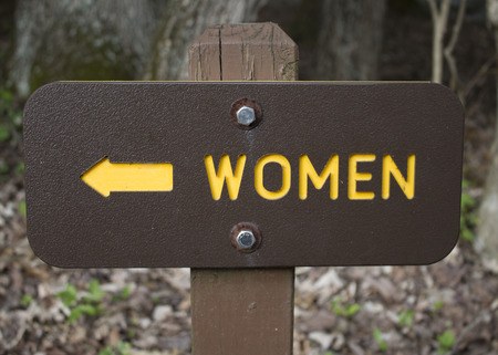 A Yellow and Brown sign women with arrowの写真素材