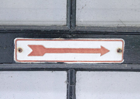 An Old Red Arrow Sign Points the Wayの写真素材