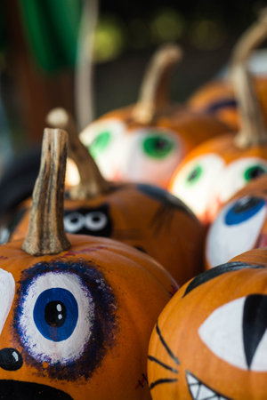 Frightened painted pumkins for halloween on a market verticalの写真素材