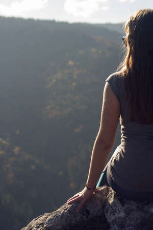 Woman sitting on the mountain top watching the viewの写真素材