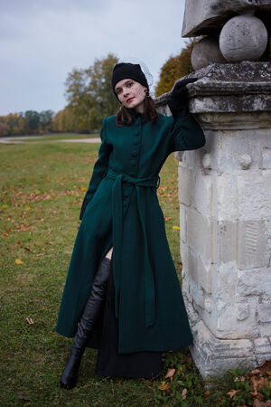 Girl in vintage green coat in the autumn parkの写真素材