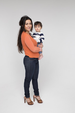 Brunette mother with her child on a white backgroundの写真素材