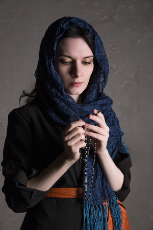 Catholic woman praying with a rosary. Russian woman dressed black and prayingの写真素材