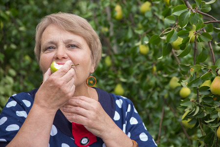 Pensioner woman under pear treeの写真素材