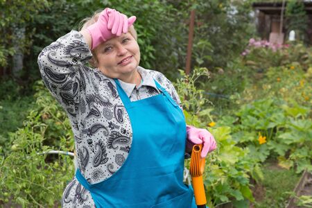 Senior tired woman digging on fieldの写真素材