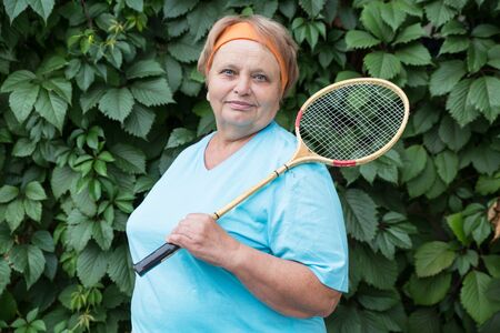 Sporty pensioner woman with racketの写真素材