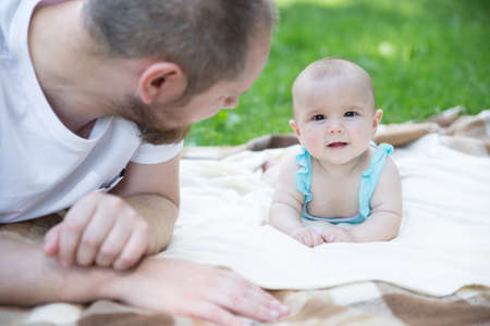 Baby girl crawling on the grass. Selective focus on her eyes.の写真素材