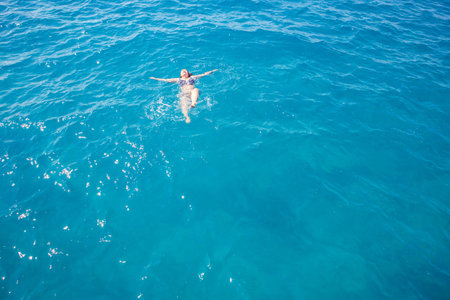 Active senior woman swimming in blue water on vacation
