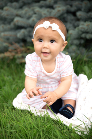 Portrait of pretty baby outdoorwearing dress and bowの写真素材