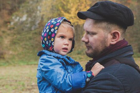Father holds daughter on hand while she is cryingの写真素材
