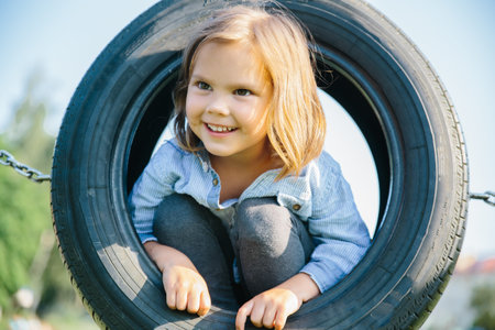 4-years girl in playground in round swing