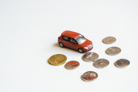 Car toy with money coins on white backgroundの写真素材