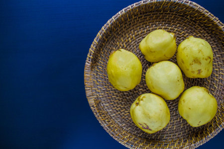Quince in wicker basket on blue background