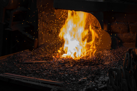 Blacksmith forging iron in workshopの写真素材