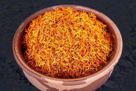 Saffron spice in pot isolated on blackの写真素材
