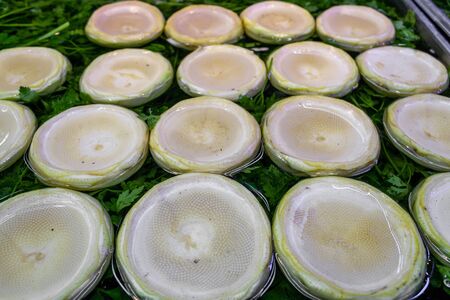 Peeled and cleaned raw artichoke in the water on the parsleyの写真素材