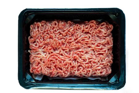Raw minced meat on a plastic black plate, white isolated backgroundの写真素材