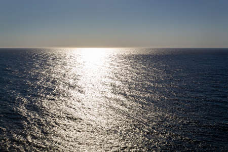 Sunset over the sea with reflection on waterの写真素材