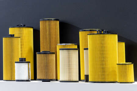 Car engine oil filters in various sizes. isolated black backgroundの写真素材