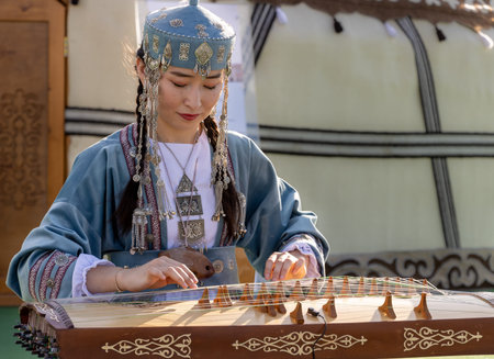 Istanbul, Turkey June 06 2024: A young girl from Kazakhstan plays the Jetigen string instrument in traditional clothes at the cultural festival held in Istanbul.のeditorial素材