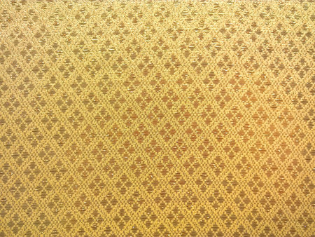 The pattern on golden silk. Silk texture.