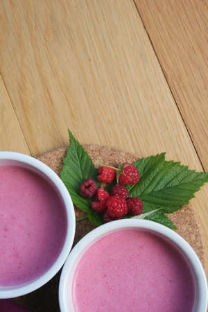 Raspberry pink cream in ceramic bowls on wooden backgroundの写真素材