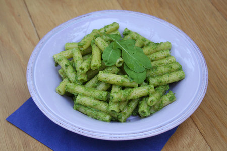 pasta with arugula pesto in a plate on wooden tableの写真素材