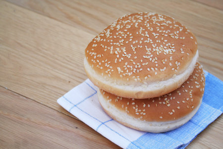 Round burger bread with sesame on wooden table