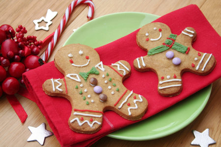 Gingerbread men cookies on red napkin on wooden table. Christmas festive background