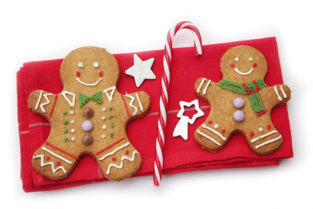 Gingerbread men on a napkin with Christmas decorations isolated on white background