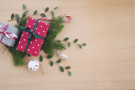 Christmas gift boxes on wooden table with green branches and copy space