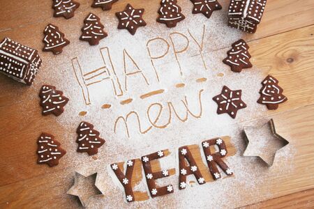 New Year's Eve background. Homemade chocolate cookies in shape of Happy new year on a wooden tableの写真素材