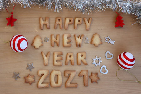Happy New year cookies. Baked cookie letters on wooden table with shiny decorationsの写真素材