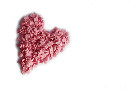 Heart made of pink heart sprinkles isolated on white background. Valentine's day background with copy spaceの写真素材