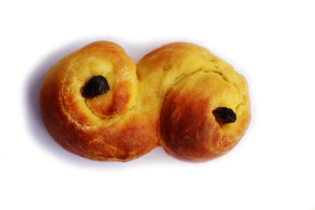 Traditional swedish saffron bun with raisins called Lussekatter on white background.の写真素材