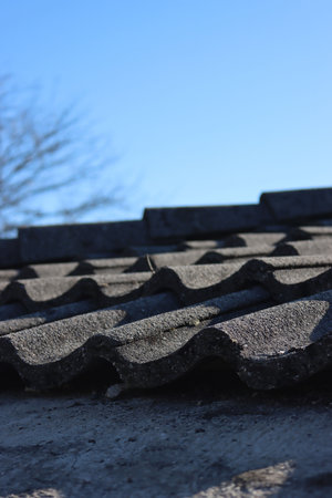 Removing Gray cement roofing tiles damaged by weather on top of a house in Italy