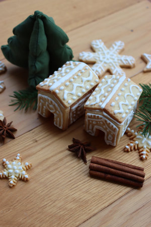 Small Gingerbread houses with many gingerbread cookies in shape of stars and snowflake  on wooden...