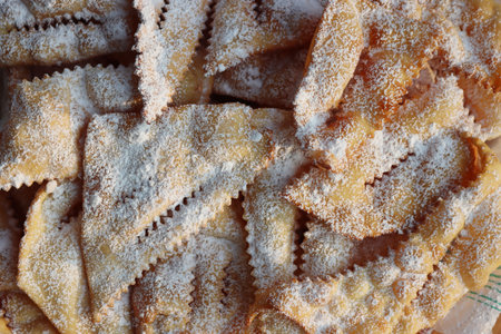 Italian Carnival pastry. Traditional sweet crisp pastry deep-fried and sprinkled with powdered sugar. Chiacchere or crostoli, bugie, cenci texture backgroundの写真素材