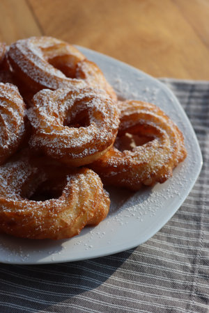 Top view of fried Zeppole with cinnamon and powdered sugar. Neapolitan homemade sweet pastry  on...