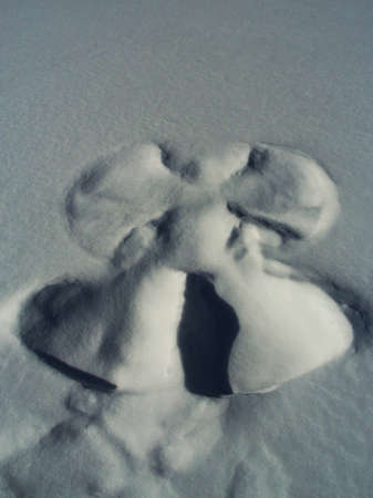 Pattern of angel imprinted in snow on a surface of a frozen lake  Smooth texture thanks to fresh snow covering the angel の写真素材