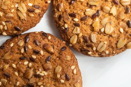 Macro photo of brown dietary low-calorie fitness cereal biscuits with sprinkling closeup on white background.の写真素材