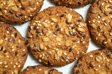 Macro photo of brown dietary low-calorie fitness cereal biscuits with sprinkling closeup on white background.の写真素材