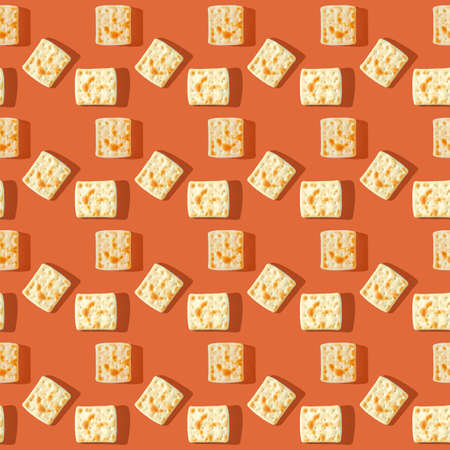 Photo in the form of a seamless pattern. Yellow-brown biscuits with shadows on a colored orange background. High quality photoの写真素材