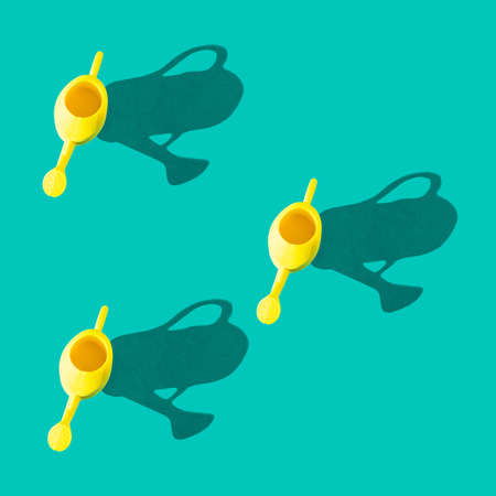 Photo in the form of a seamless pattern. Yellow watering can for watering flowers with shadows on a colored turquoise background. High quality photoの写真素材
