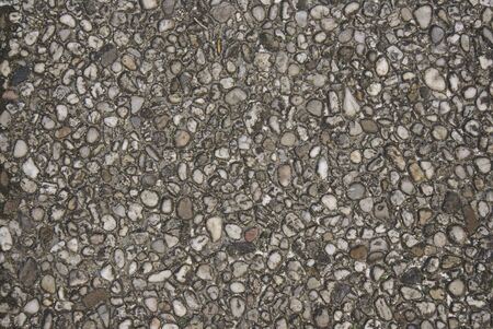 Different sized and shaped pebbles in concreteの写真素材