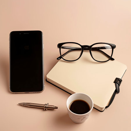 Smartphone with glasses, notebook and coffee on beige background.の素材