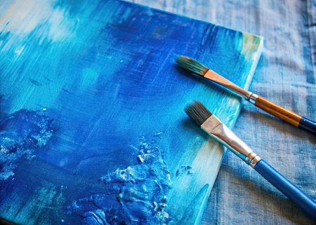 Paint brushes and blue palette on a wooden background. Selective focus.の素材