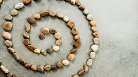 Zen-Inspired Spiral Pebble Arrangement on Sandy Groundの素材