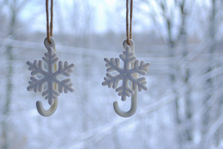 Snowflake-Shaped Ornaments Hanging in Winter Sceneの素材