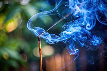 Incense stick with blue smoke on a green background. The concept of aromatherapy.の素材